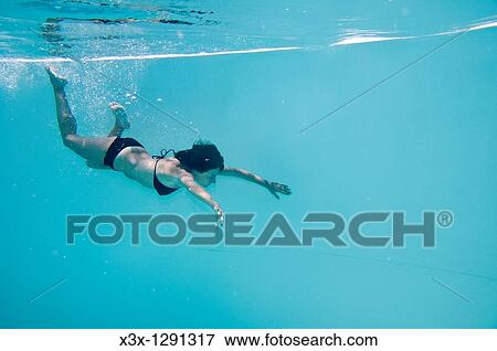 A woman swimming underwater View Large Photo Image Stock Photo - A woman swimming underwater. Fotosearch