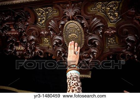 Stock Photo - A woman touches a throne during an Easter Holy Week procession in Carmona village, Seville province, Andalusia, Spain, April 20, 2011. Fotosearch