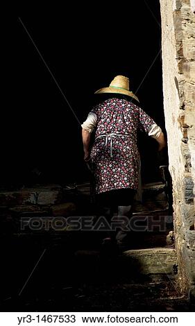 Stock Image - A woman up the stairs of her home in El Bierzo, Leon province, in the French Way that leads to Santiago de Compostela, Spain.. Fotosearch