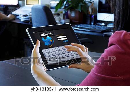 A woman using a Twitter application on an iPad at the office View Large Photo Image Stock Image - A woman using a Twitter application on an iPad at the office. Fotosearch