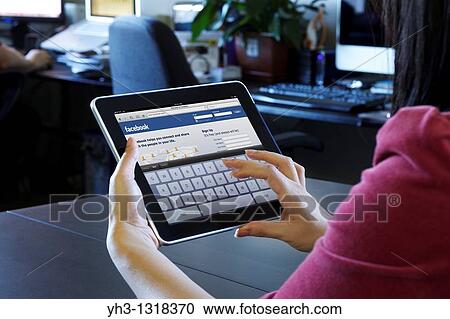A woman using an iPad to check her Facebook page View Large Photo Image Stock Image - A woman using an iPad to check her Facebook page. Fotosearch