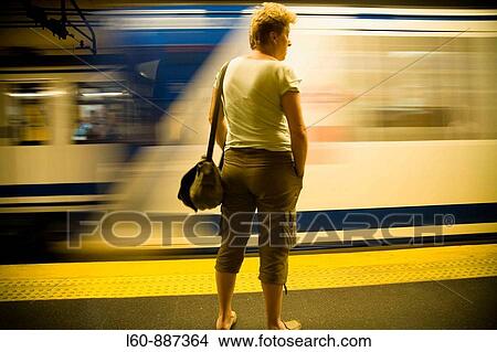 A woman waiting for a train on the Underground, Madrid, Spain. View Large Photo Image Picture - A woman waiting for a train on the Underground, Madrid, Spain.. Fotosearch
