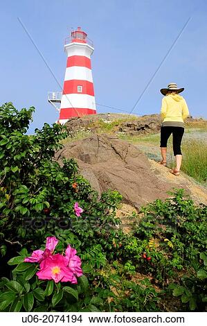 A woman walking up a slope to view the Brier island lighthouse in Nova Scotia, Canada View Large Photo Image Picture - A woman walking up a slope to view the Brier island lighthouse in Nova Scotia, Canada. Fotosearch