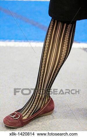 Picture - A woman wearing patterned stockings indoors. Fotosearch