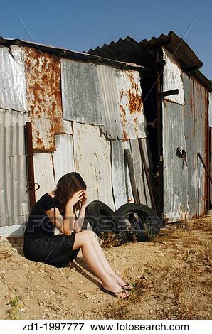 A woman who is a victim of abuse is sitting on outside an old shed sad and depressed. View Large Photo Image Stock Photo - A woman who is a victim of abuse is sitting on outside an old shed sad and depressed.. Fotosearch