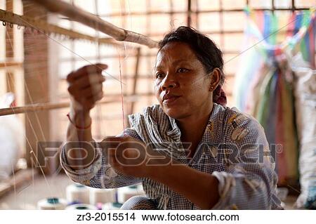 Picture - A women works in a small village textile factory outside of Phnom Penh, Cambodia.. Fotosearch