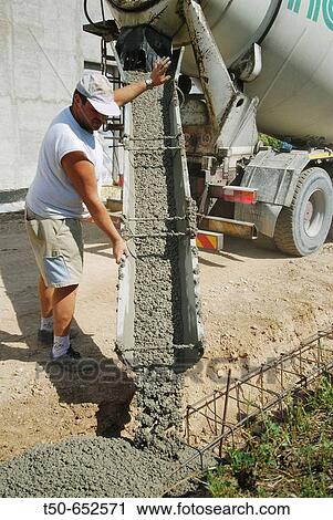 A worker pours concrete into forms for a new home foundation View Large Photo Image Stock Image - A worker pours concrete into forms for a new home foundation. Fotosearch