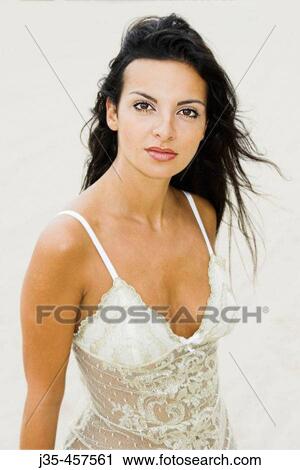 A young 20? s, 30's woman wearing a lace white top, looks into camera with a pleased and sexy expression with her long black hair blowing in a breeze View Large Photo Image Stock Image - A young 20? s, 30's woman wearing a lace white top, looks into camera with a pleased and sexy expression with her long black hair blowing in a breeze. Fotosearch