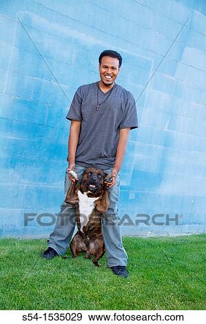 Stock Photo - A young African-American man with his pitbull in Spokane, Washington, USA. Fotosearch