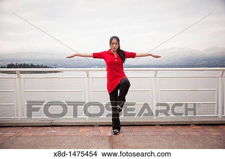 A young Asian woman does the Vrksasana Tree Pose yoga pose at Canada Place, Vancouver, British Columbia, Canada View Large Photo Image Picture - A young Asian woman does the Vrksasana Tree Pose yoga pose at Canada Place, Vancouver, British Columbia, Canada. Fotosearch