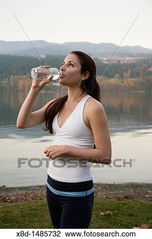 A young athletic woman drinking from a bottle of water, Inlet Park, Port Moody, British Columbia, Canada View Large Photo Image Stock Image - A young athletic woman drinking from a bottle of water, Inlet Park, Port Moody, British Columbia, Canada. Fotosearch