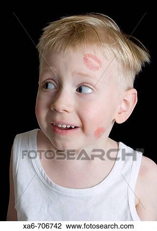 A young blond-haired, blue-eyed boy wearing a white vest with red lipstick kisses on his face. Studio lighting, black background. View Large Photo Image Stock Image - A young blond-haired, blue-eyed boy wearing a white vest with red lipstick kisses on his face. Studio lighting, black background.. Fotosearch