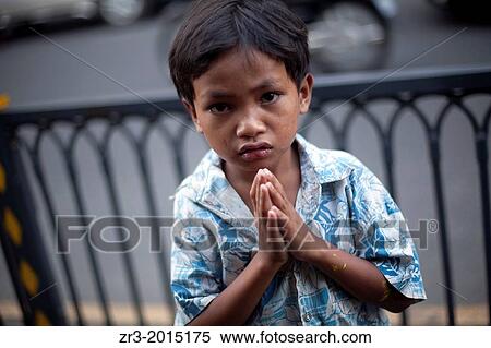 A young boy begs to tourists in Phnom Penh, Cambodia. View Large Photo Image Stock Photography - A young boy begs to tourists in Phnom Penh, Cambodia.. Fotosearch