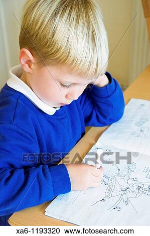 A young boy concentrates as he completes his written homework View Large Photo Image Stock Image - A young boy concentrates as he completes his written homework. Fotosearch