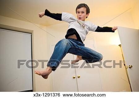 A young boy doing a flying smash kick View Large Photo Image Stock Photograph - A young boy doing a flying smash kick. Fotosearch