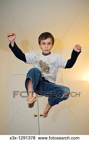 Stock Photo - A young boy jump frozen in midair. Fotosearch