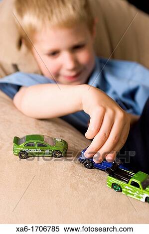 A young boy plays with some small toy cars View Large Photo Image Stock Photography - A young boy plays with some small toy cars. Fotosearch