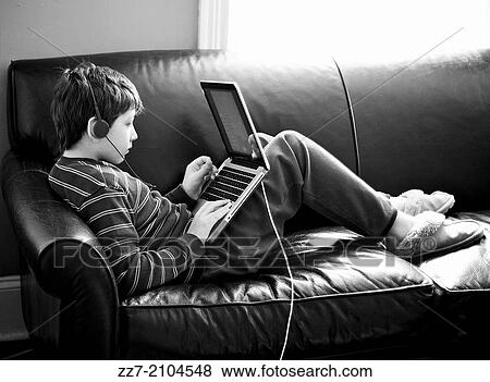 A young boy uses a computer at home. View Large Photo Image Stock Photo - A young boy uses a computer at home.. Fotosearch