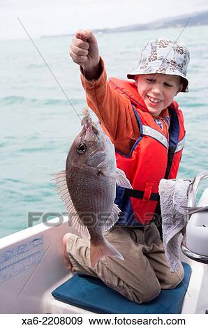 A young boy who has just caught a fish. View Large Photo Image Stock Photo - A young boy who has just caught a fish.. Fotosearch