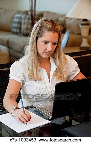 A young business woman working on her computer at a desk View Large Photo Image Stock Image - A young business woman working on her computer at a desk. Fotosearch