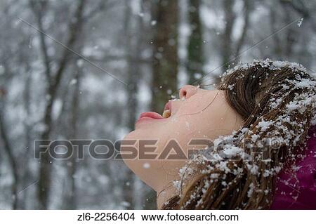 A young caucasian 8 years old girl trying to catch in her mouth the snow flakes falling in the winter, in Durham, North Carolina View Large Photo Image Picture - A young caucasian 8 years old girl trying to catch in her mouth the snow flakes falling in the winter, in Durham, North Carolina. Fotosearch