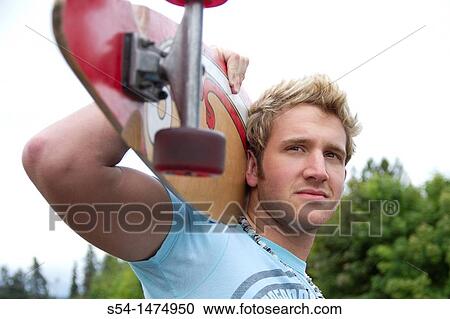 Stock Image - A young, caucasian male with a longboard skateboard. Fotosearch