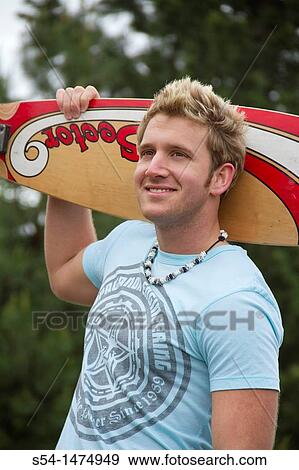 Stock Photo - A young, caucasian male with a longboard skateboard. Fotosearch