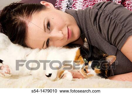 A young caucasian woman and her calico cat indoors View Large Photo Image Stock Image - A young caucasian woman and her calico cat indoors. Fotosearch