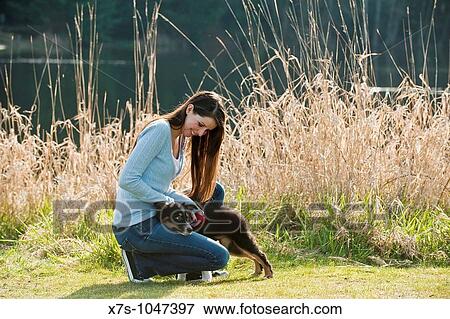 A young Caucasian woman and her puppy dog at the park View Large Photo Image Stock Photo - A young Caucasian woman and her puppy dog at the park. Fotosearch