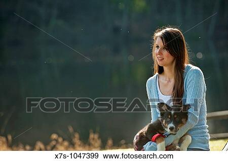 A young Caucasian woman and her puppy dog at the park View Large Photo Image Stock Photo - A young Caucasian woman and her puppy dog at the park. Fotosearch