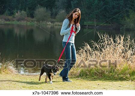 Stock Photograph - A young Caucasian woman and her puppy dog at the park. Fotosearch