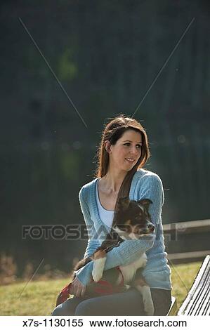 Stock Photography - A young Caucasian woman and her puppy dog at the park. Fotosearch