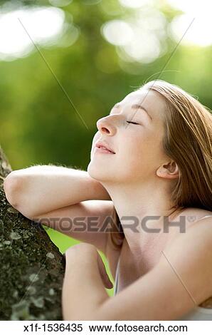 a young caucasian woman eyes closed, outdoors in a woodland glade, uk View Large Photo Image Stock Photography - a young caucasian woman eyes closed, outdoors in a woodland glade, uk. Fotosearch