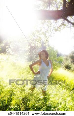 Stock Image - A young caucasian woman outdoors in a park. Fotosearch