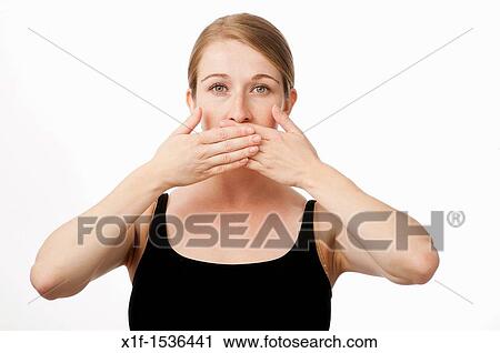 a young caucasian woman with her hands over her mouth speak no evil View Large Photo Image Stock Image - a young caucasian woman with her hands over her mouth speak no evil. Fotosearch
