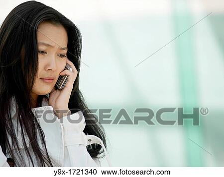 A young Chinese business woman using her mobile phone PDA in the city View Large Photo Image Stock Image - A young Chinese business woman using her mobile phone PDA in the city. Fotosearch