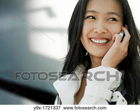 A young Chinese business woman using her mobile phone PDA in the city View Large Photo Image Stock Photo - A young Chinese business woman using her mobile phone PDA in the city. Fotosearch