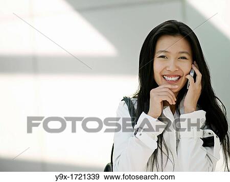 A young Chinese business woman using her mobile phone PDA in the city View Large Photo Image Stock Photo - A young Chinese business woman using her mobile phone PDA in the city. Fotosearch