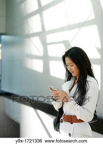 A young Chinese business woman using her mobile phone PDA in the city View Large Photo Image Stock Photograph - A young Chinese business woman using her mobile phone PDA in the city. Fotosearch