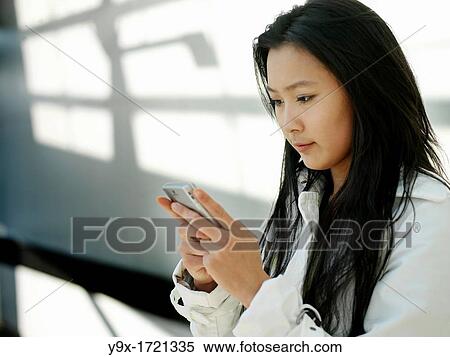 A young Chinese business woman using her mobile phone PDA in the city View Large Photo Image Stock Photography - A young Chinese business woman using her mobile phone PDA in the city. Fotosearch