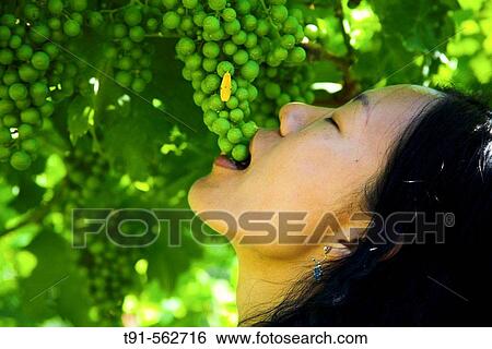 a young chinese girl enjoys fresh grapes right away View Large Photo Image Stock Photograph - a young chinese girl enjoys fresh grapes right away. Fotosearch