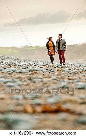 A young couple, boyfriend and girlfriend, together on a windy afternoon on the seashore, west wales UK View Large Photo Image Stock Photo - A young couple, boyfriend and girlfriend, together on a windy afternoon on the seashore, west wales UK. Fotosearch