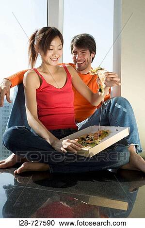 a young couple drinking and eating pizza View Large Photo Image Stock Image - a young couple drinking and eating pizza. Fotosearch