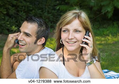 A young couple each talking on their mobile phone, Germany, Europe View Large Photo Image Stock Photo - A young couple each talking on their mobile phone, Germany, Europe. Fotosearch