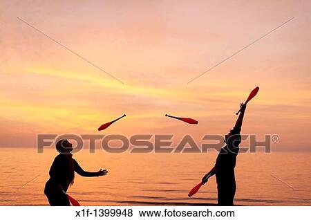 A young couple Juggling with clubs on the beach, spring evening sunset, Aberystwyth Wales UK View Large Photo Image Stock Photo - A young couple Juggling with clubs on the beach, spring evening sunset, Aberystwyth Wales UK. Fotosearch