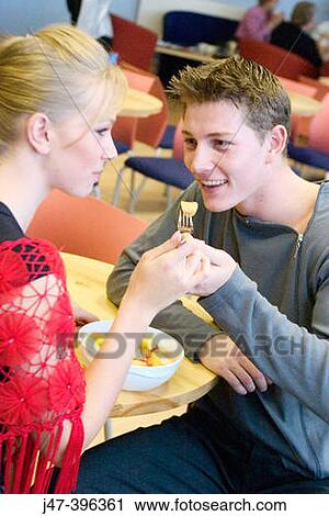 A young couple sitting in a cafe sharing a bowl of fruit smiling View Large Photo Image Stock Image - A young couple sitting in a cafe sharing a bowl of fruit smiling. Fotosearch