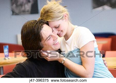 A young couple sitting in a cafe cuddling View Large Photo Image Stock Photography - A young couple sitting in a cafe cuddling. Fotosearch