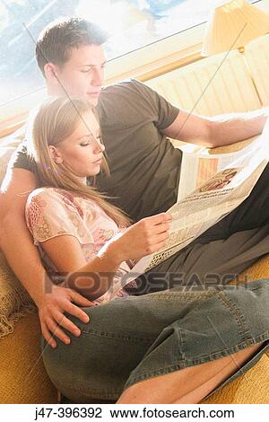 A young couple sitting reading the newspaper View Large Photo Image Stock Image - A young couple sitting reading the newspaper. Fotosearch