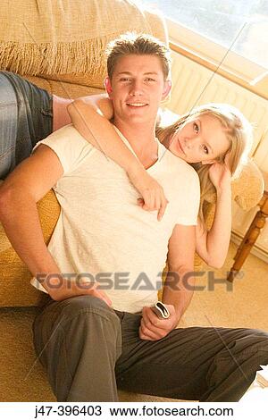 A young couple sitting together smiling into camera View Large Photo Image Stock Image - A young couple sitting together smiling into camera. Fotosearch