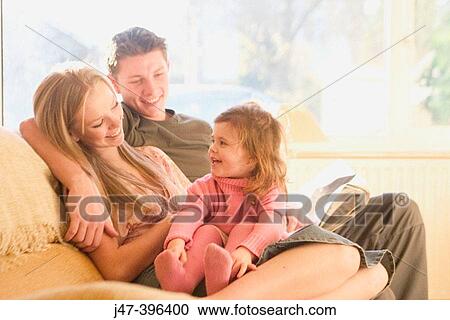 A young couple sitting together with a 3 year old gir on her knee all smiling View Large Photo Image Stock Image - A young couple sitting together with a 3 year old gir on her knee all smiling. Fotosearch